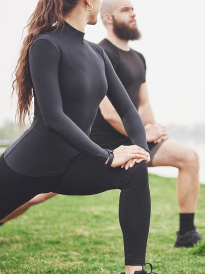 A couple stretching outdoors demonstrating RV healthy living